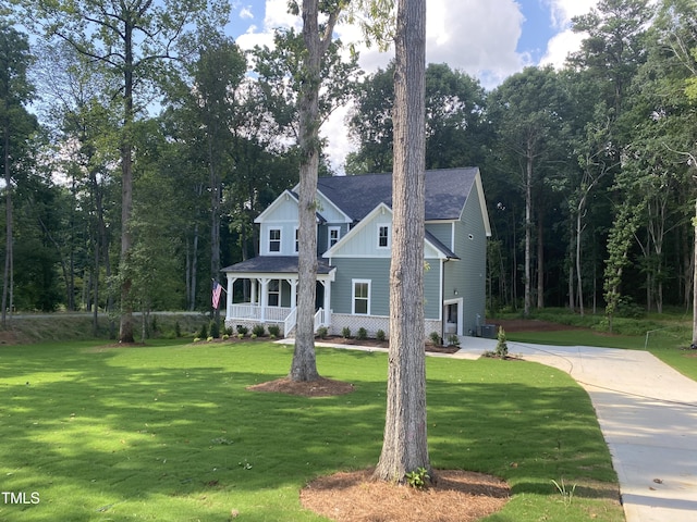 5036 Trotter Dr, Raleigh, NC 27603 - view of front facade featuring a front lawn, covered porch, concrete driveway, and board and batten siding