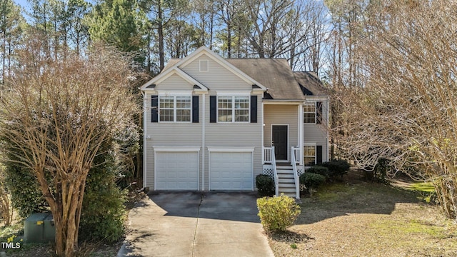 split foyer home featuring concrete driveway and an attached garage