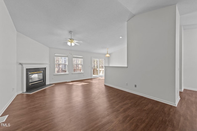 unfurnished living room with a premium fireplace, baseboards, vaulted ceiling, and wood finished floors