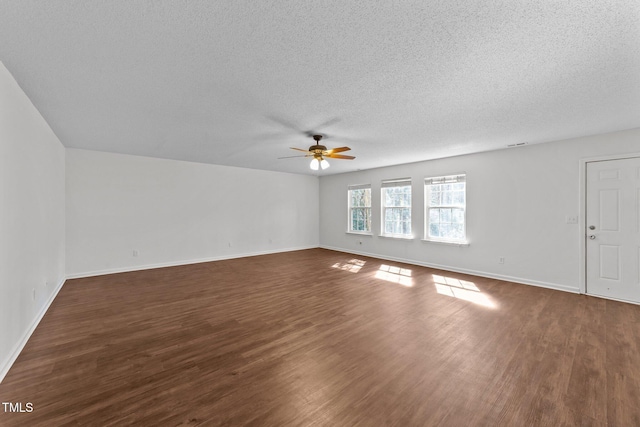 unfurnished living room featuring ceiling fan, a textured ceiling, dark wood finished floors, and baseboards