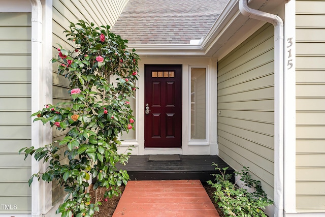 property entrance with a shingled roof