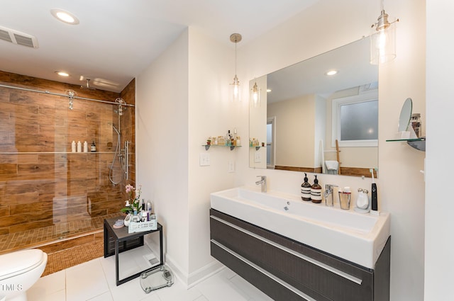 full bathroom with toilet, visible vents, tiled shower, and vanity