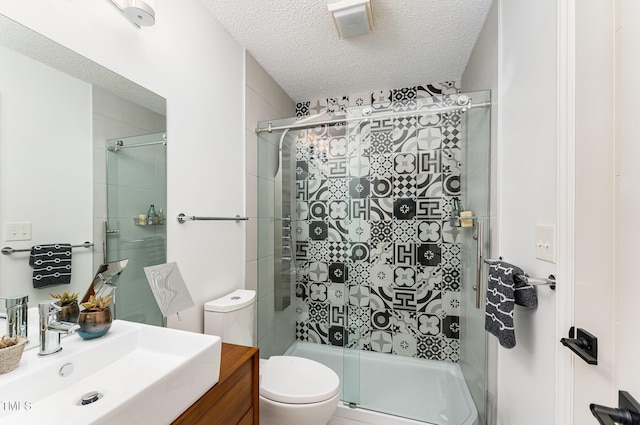 bathroom featuring a textured ceiling, vanity, a shower stall, and toilet