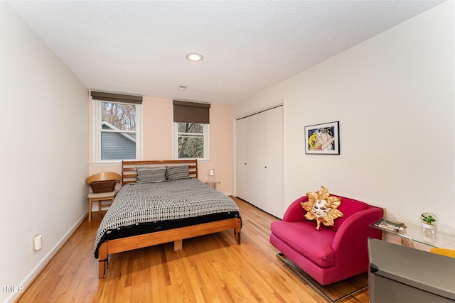 bedroom featuring light wood finished floors, a closet, and a textured ceiling