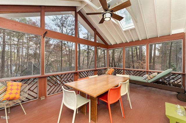 sunroom with lofted ceiling with skylight, plenty of natural light, and ceiling fan