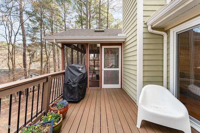 deck with a sunroom and grilling area