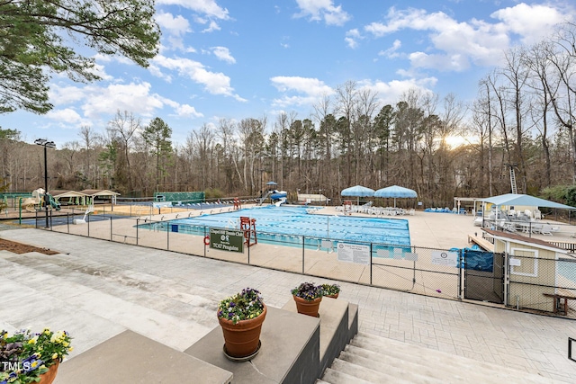 pool with fence and a patio