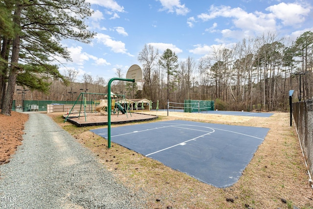 view of sport court featuring community basketball court, playground community, fence, and volleyball court