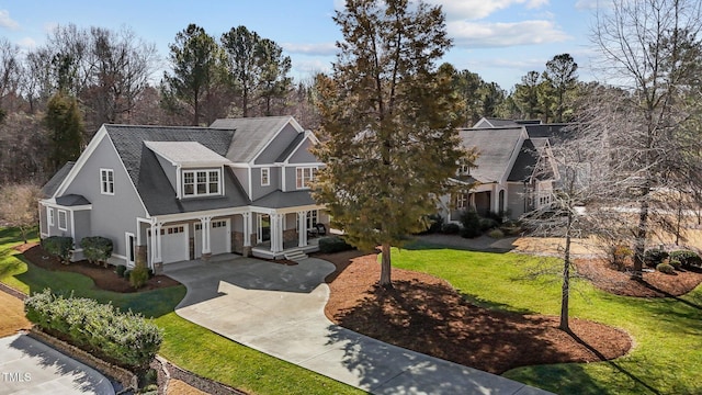 view of front of house with a garage, concrete driveway, and a front lawn