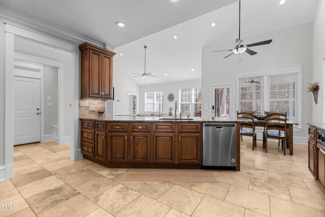 kitchen with stainless steel dishwasher, vaulted ceiling, a sink, ceiling fan, and dark stone counters