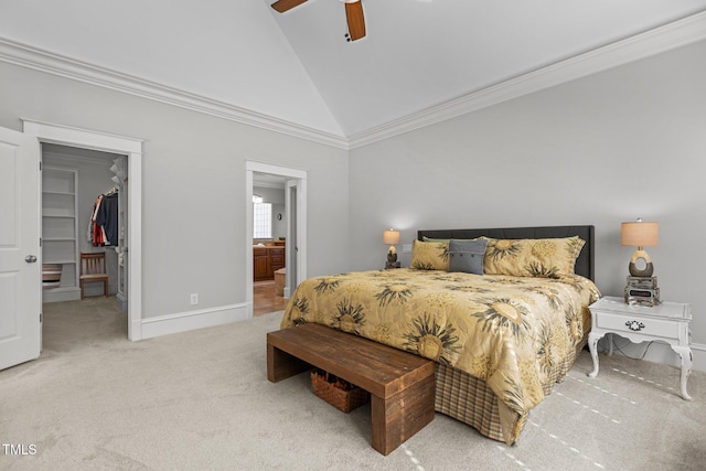 bedroom with connected bathroom, light carpet, baseboards, a spacious closet, and ornamental molding