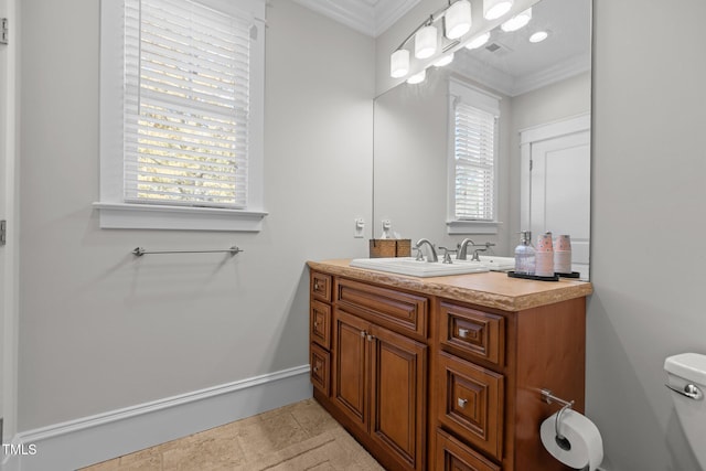 half bathroom featuring ornamental molding, plenty of natural light, and vanity