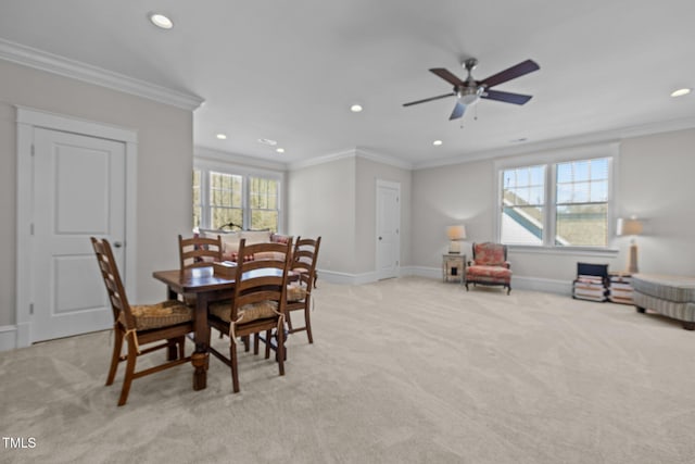 dining space featuring baseboards, light colored carpet, and crown molding