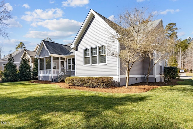 rear view of house featuring a sunroom and a yard