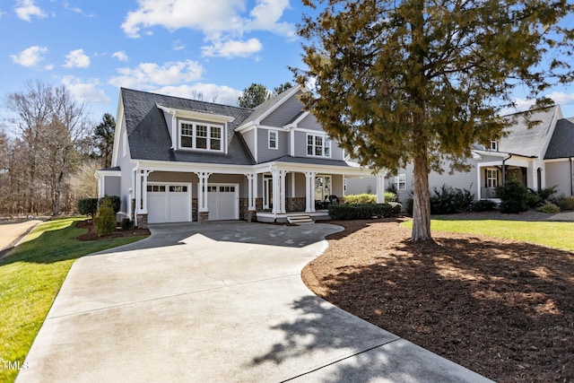 view of front of house featuring an attached garage, concrete driveway, stone siding, and a front yard