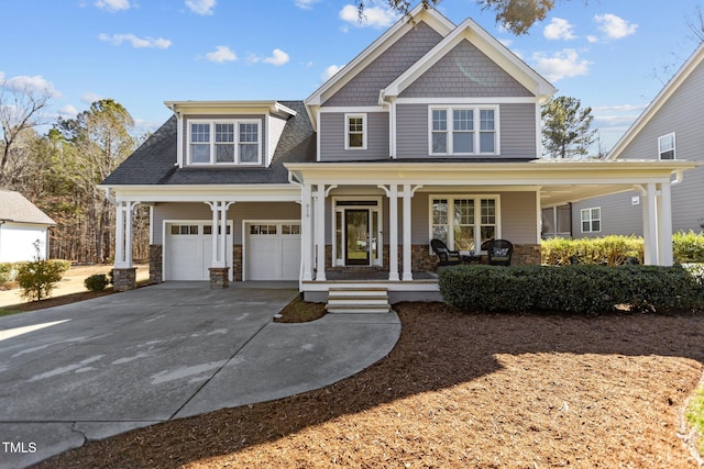 view of front of house with stone siding, covered porch, an attached garage, and concrete driveway