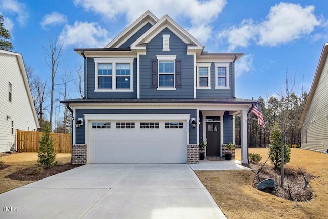 craftsman inspired home featuring brick siding, fence, driveway, and an attached garage