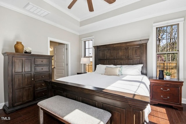 bedroom with dark wood-style floors, multiple windows, and visible vents