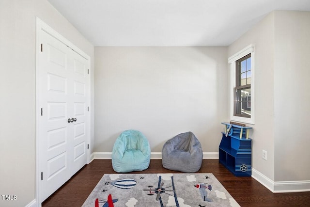 living area with baseboards and wood finished floors