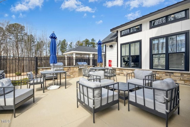 view of patio with area for grilling, fence, an outdoor living space, and a grill