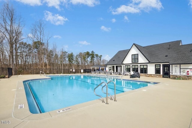 community pool with fence and a patio