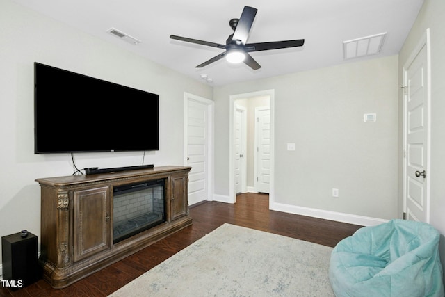 living room with dark wood-type flooring, visible vents, and baseboards