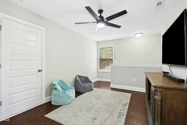 living area with a ceiling fan, visible vents, dark wood finished floors, and baseboards