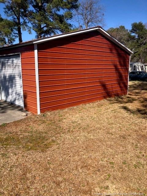 view of home's exterior with a yard and an outdoor structure