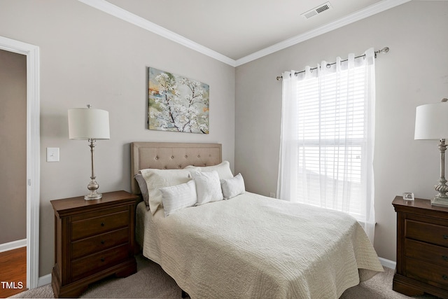 bedroom featuring baseboards, visible vents, and crown molding