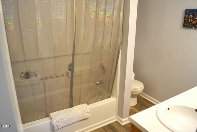 full bathroom featuring toilet, wood finished floors, vanity, baseboards, and shower / bathtub combination with curtain