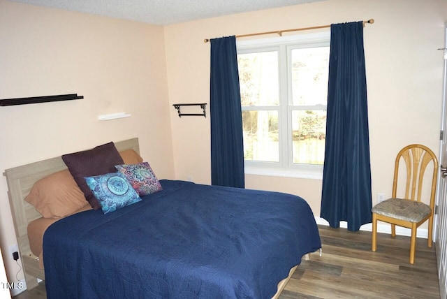 bedroom featuring multiple windows and wood finished floors