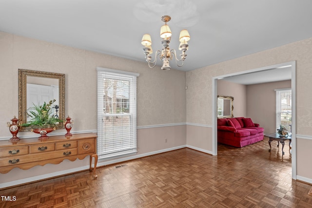 interior space with visible vents, baseboards, and an inviting chandelier