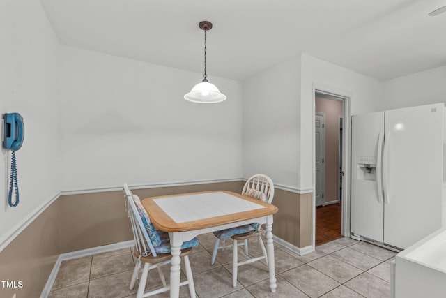 dining space featuring light tile patterned flooring and baseboards