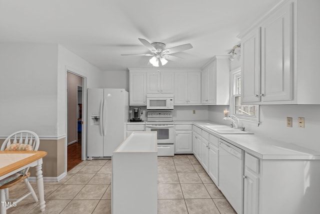 kitchen featuring white appliances, light tile patterned floors, white cabinets, a center island, and a sink