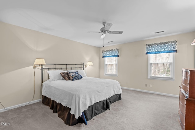 carpeted bedroom with baseboards, multiple windows, and visible vents