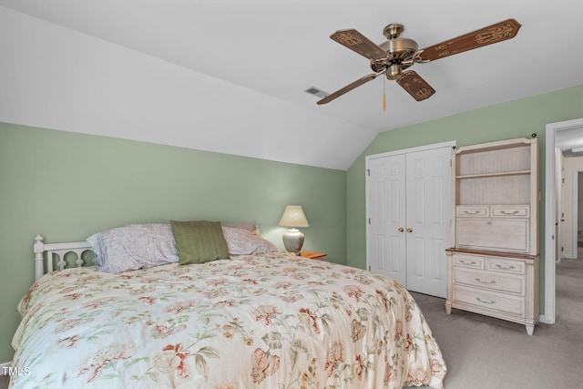 carpeted bedroom featuring a closet, visible vents, vaulted ceiling, and ceiling fan