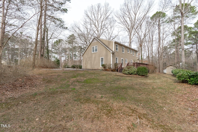 view of property exterior with an outdoor structure, a yard, and a wooden deck