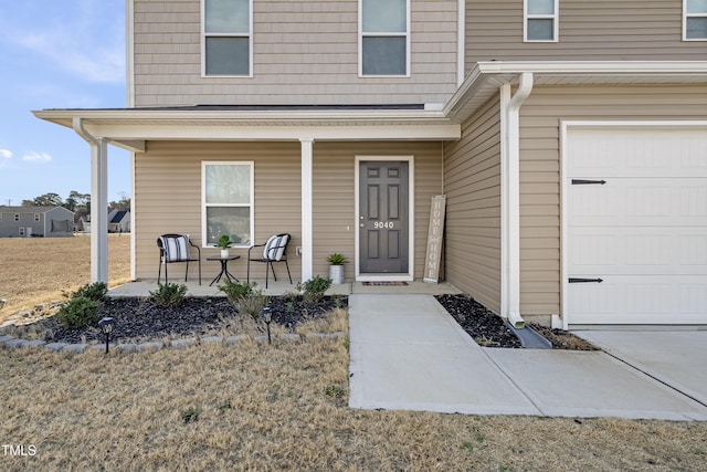 entrance to property with covered porch and an attached garage