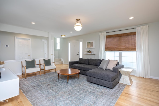 living area featuring light wood-style floors, recessed lighting, baseboards, and stairs