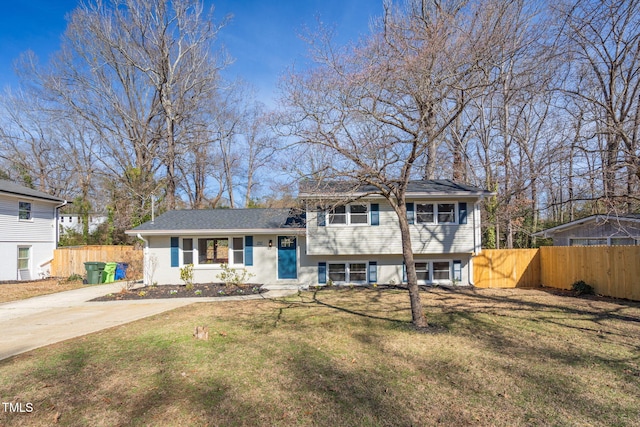 split level home with a front yard, concrete driveway, and fence