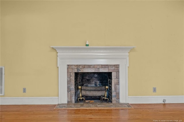 room details with a tile fireplace and hardwood / wood-style floors