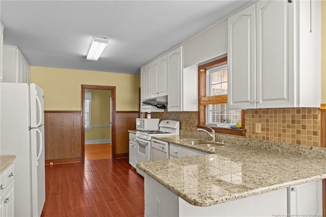 kitchen featuring sink, white appliances, light stone countertops, and white cabinets