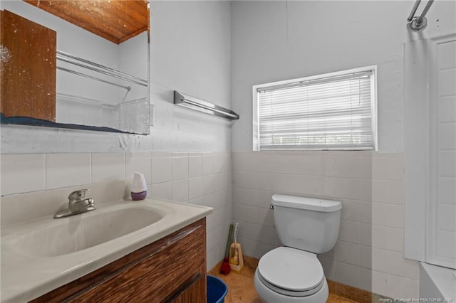 bathroom featuring vanity, tile walls, and toilet