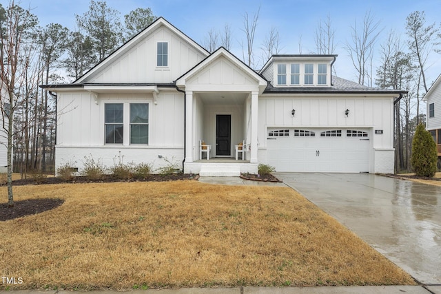 modern inspired farmhouse with an attached garage, concrete driveway, roof with shingles, a front lawn, and board and batten siding