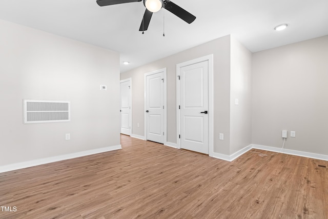 unfurnished bedroom featuring a ceiling fan, baseboards, visible vents, and light wood finished floors