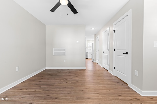 empty room with visible vents, baseboards, light wood-style floors, and a ceiling fan