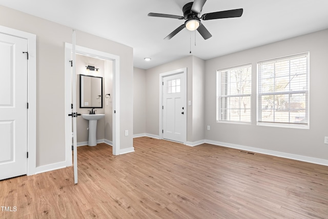 entryway featuring visible vents, ceiling fan, baseboards, and light wood-style floors