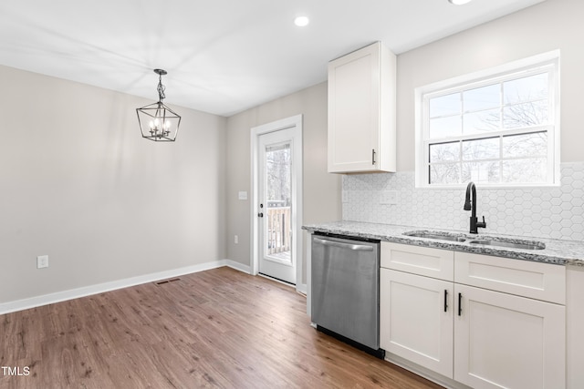 kitchen with a sink, light stone counters, white cabinetry, decorative backsplash, and dishwasher