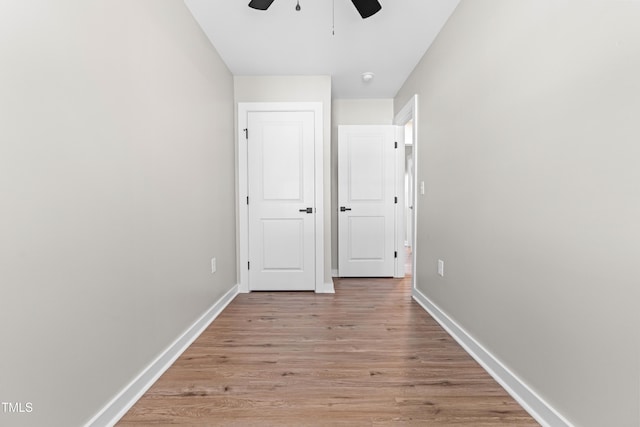 unfurnished bedroom featuring light wood-style flooring, baseboards, and ceiling fan