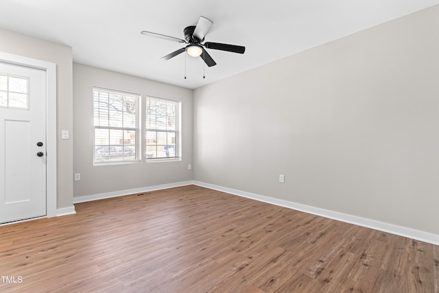 foyer entrance with baseboards, ceiling fan, and light wood finished floors